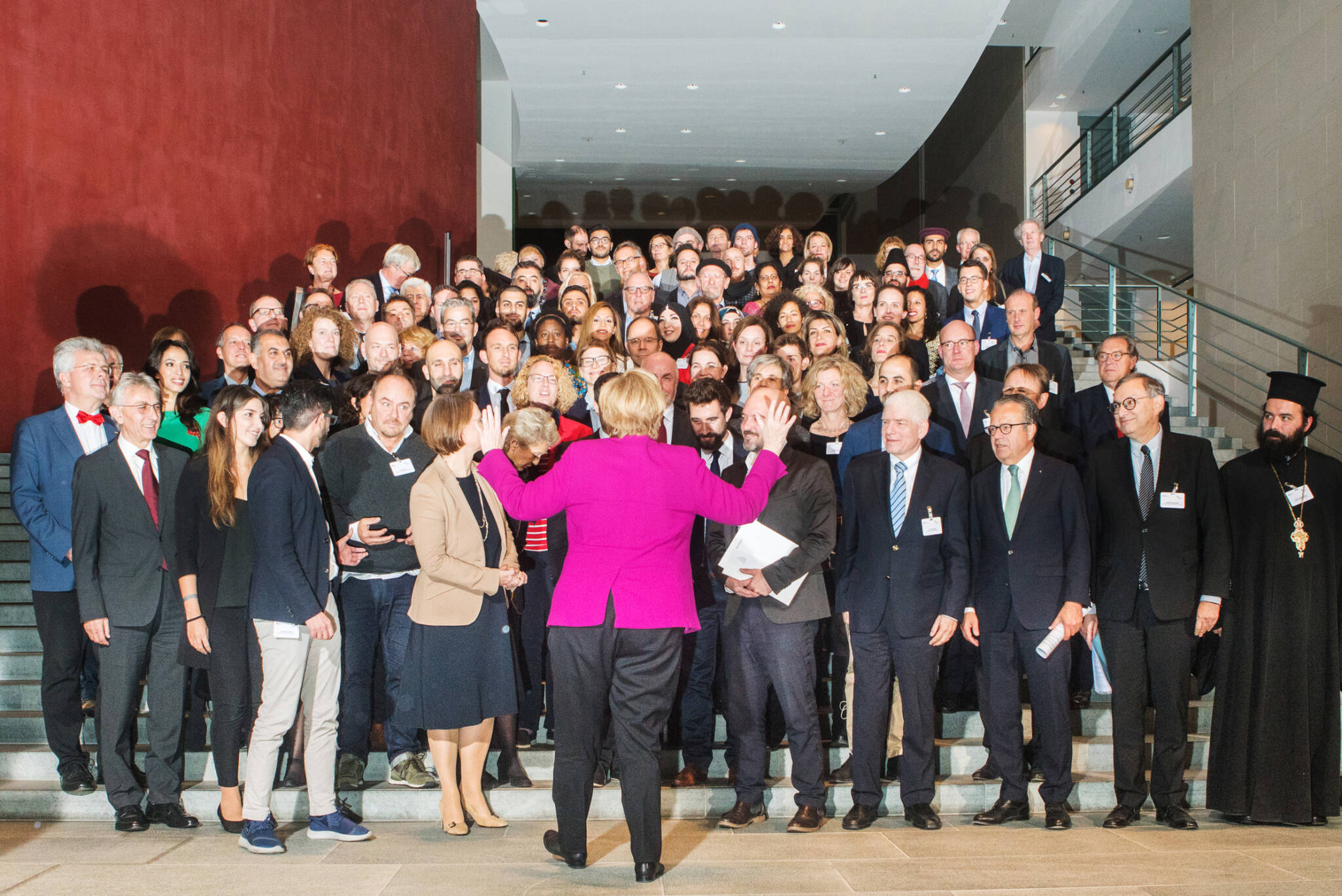 Angela Merkel dirigiert ein Gruppenfoto für uns